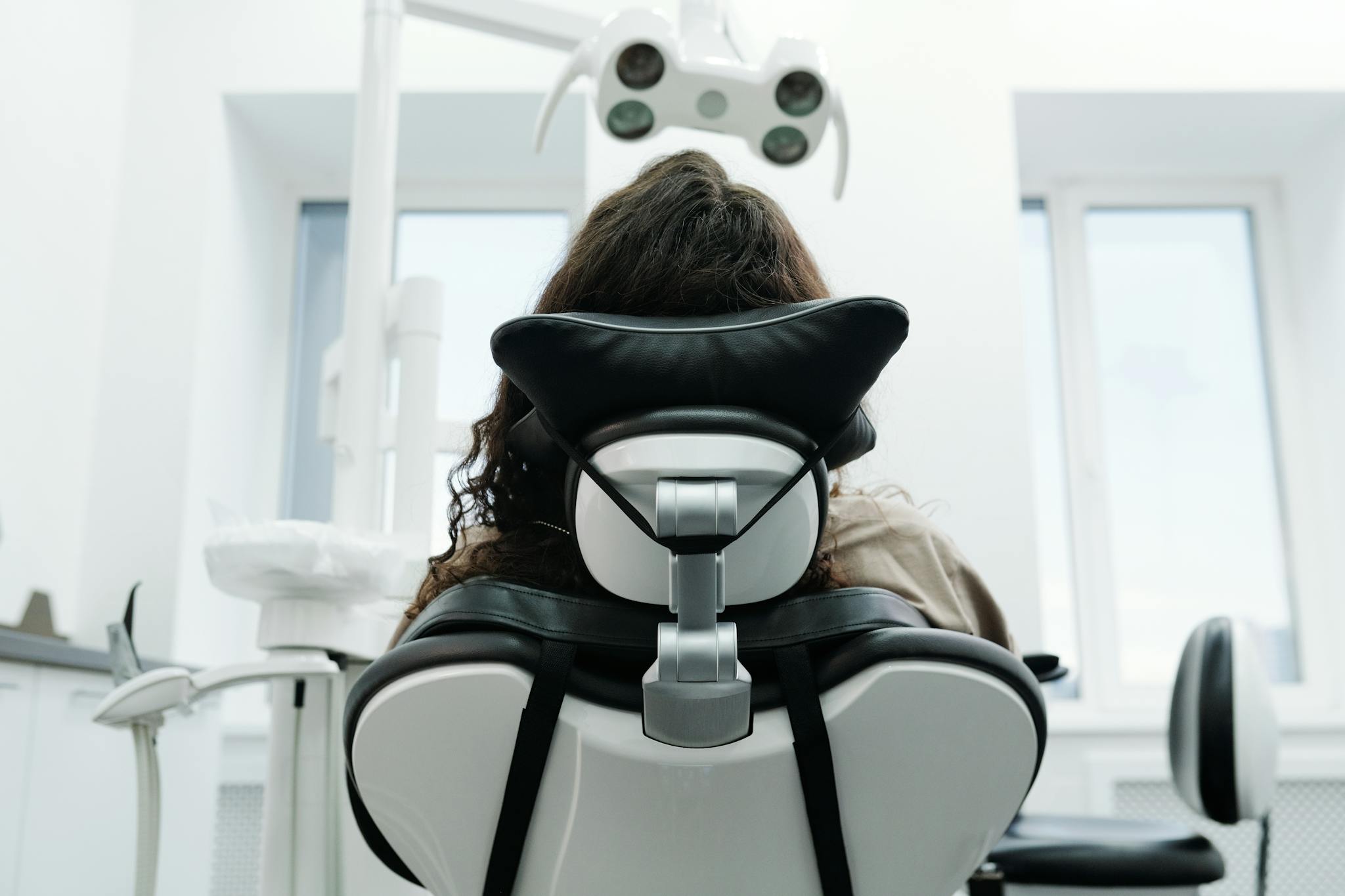 Patient sitting in a dental chair inside a modern clinic, ready for an examination.